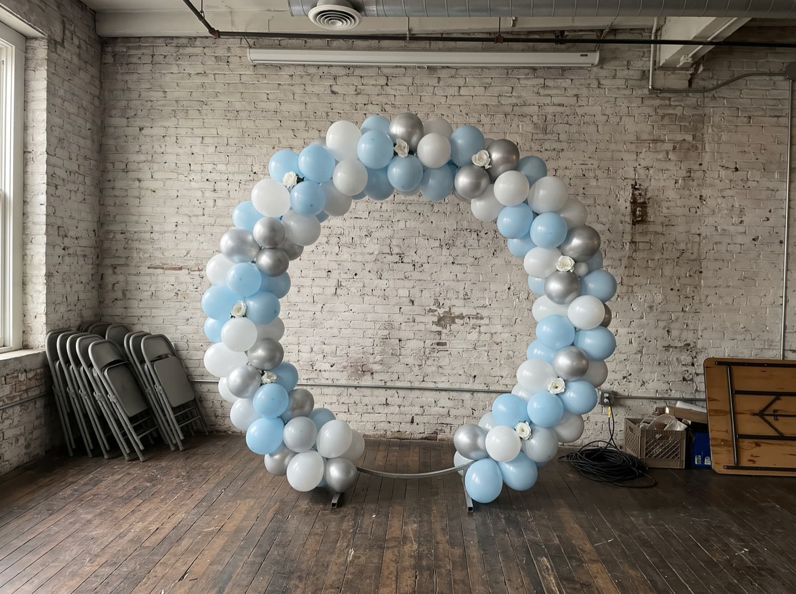 Round balloon arch in pale blue and silver in a loft